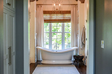 Design ideas for a mid-sized country master bathroom in Other with furniture-like cabinets, white cabinets, a freestanding tub, a corner shower, a two-piece toilet, marble, medium hardwood floors, an undermount sink, marble benchtops, brown floor, a hinged shower door and white benchtops.