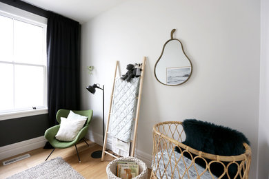 Inspiration for a small contemporary nursery for boys in Auckland with white walls and light hardwood floors.