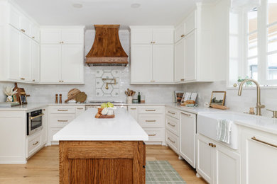 Eat-in kitchen - large transitional u-shaped vinyl floor and brown floor eat-in kitchen idea in Dallas with a farmhouse sink, shaker cabinets, white cabinets, quartzite countertops, white backsplash, ceramic backsplash, stainless steel appliances, two islands and white countertops