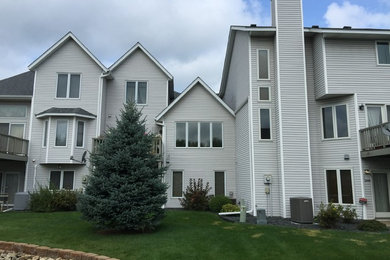 Huge gray three-story townhouse exterior idea in Minneapolis with a hip roof and a shingle roof