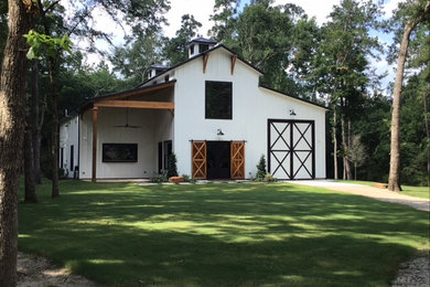 Huge mountain style white two-story wood and board and batten exterior home photo in Houston with a shingle roof and a black roof