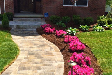 Photo of a mid-sized modern front yard partial sun garden in Detroit with brick pavers.