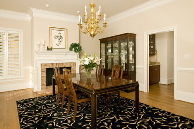 Inspiration for a traditional dining room in Richmond with beige walls, medium hardwood floors, a standard fireplace and a brick fireplace surround.