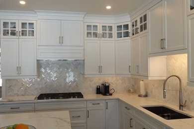Large arts and crafts u-shaped medium tone wood floor and brown floor eat-in kitchen photo in Toronto with a double-bowl sink, white cabinets, quartz countertops, gray backsplash, ceramic backsplash, stainless steel appliances, an island and flat-panel cabinets