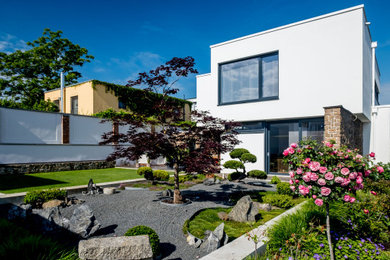 Mittelgroßes, Zweistöckiges Modernes Einfamilienhaus mit Betonfassade, weißer Fassadenfarbe und Flachdach in Sonstige