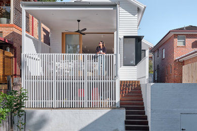 Foto de fachada de casa blanca y gris actual de tamaño medio de dos plantas con revestimiento de aglomerado de cemento, tejado a dos aguas y tejado de metal
