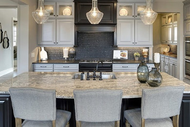 Open concept kitchen - large transitional single-wall dark wood floor and brown floor open concept kitchen idea in Minneapolis with an undermount sink, gray cabinets, granite countertops, black backsplash, marble backsplash, stainless steel appliances and an island