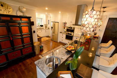 Example of a large transitional l-shaped dark wood floor and brown floor open concept kitchen design in Cleveland with an undermount sink, shaker cabinets, white cabinets, quartzite countertops, stainless steel appliances, a peninsula and beige countertops