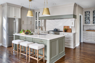 Example of a mid-sized transitional medium tone wood floor and brown floor kitchen design in Atlanta with a single-bowl sink, beige cabinets, quartz countertops, white backsplash, quartz backsplash, stainless steel appliances and white countertops