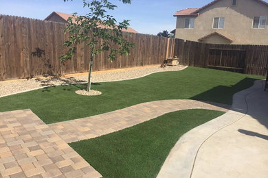 This is an example of a mid-sized traditional drought-tolerant backyard concrete paver landscaping in Other.
