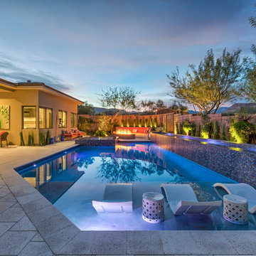 Contemporary Backyard Pool with Tiled Water Feature, Rim Flow Spa, & Fire Pit