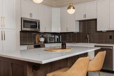 Example of a mid-sized 1960s medium tone wood floor and brown floor kitchen design in Other with an undermount sink, shaker cabinets, dark wood cabinets, quartz countertops, blue backsplash, ceramic backsplash, stainless steel appliances, an island and white countertops