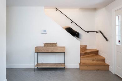 Entryway - large transitional porcelain tile and gray floor entryway idea in Vancouver with white walls and a white front door