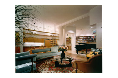 Diseño de salón con rincón musical tipo loft moderno grande con paredes blancas, suelo de madera en tonos medios y pared multimedia
