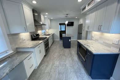 Example of a large minimalist porcelain tile and gray floor kitchen design in New York with an undermount sink, shaker cabinets, white cabinets, granite countertops, gray backsplash, ceramic backsplash, stainless steel appliances and gray countertops