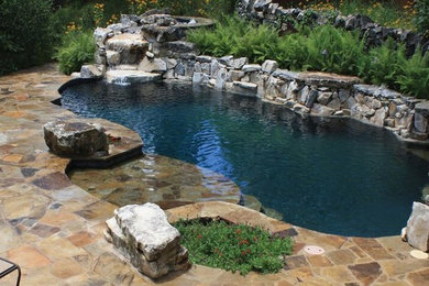 Example of a mid-sized mountain style indoor kidney-shaped pool fountain design in Austin with decking