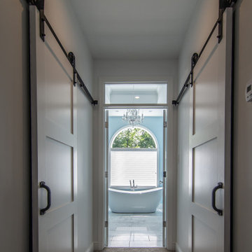 Traditional master bath utilizing frosted and clear glass to allow for needed pr