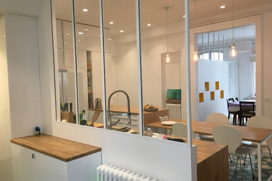 Exemple d'une grande cuisine ouverte tendance en U avec un évier encastré, un placard à porte affleurante, des portes de placard blanches, un plan de travail en bois, une crédence blanche, une crédence en feuille de verre, un électroménager blanc, carreaux de ciment au sol, une péninsule et un sol vert.