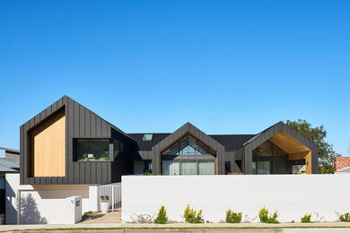 Inspiration for a large two-storey black house exterior in Geelong with metal siding, a gable roof, a metal roof and a black roof.