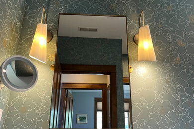 Example of a transitional porcelain tile, beige floor, single-sink and wallpaper bathroom design in Other with brown cabinets, green walls, an undermount sink, quartz countertops, white countertops and a freestanding vanity