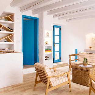 Diseño de salón para visitas mediterráneo, de tamaño medio, con paredes blancas, suelo de ladrillo, chimenea tradicional, marco de chimenea de piedra y televisor independiente