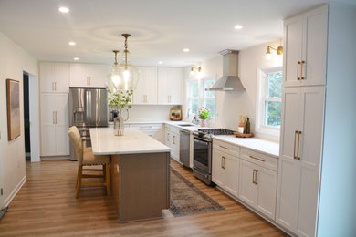 Open concept kitchen - large l-shaped medium tone wood floor and brown floor open concept kitchen idea in DC Metro with an undermount sink, recessed-panel cabinets, white cabinets, quartz countertops, stainless steel appliances, an island and white countertops