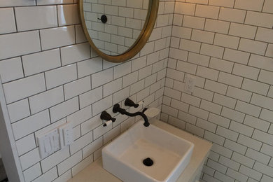 Inspiration for a small arts and crafts 3/4 bathroom in Los Angeles with flat-panel cabinets, white cabinets, a corner shower, a bidet, black and white tile, porcelain tile, white walls, porcelain floors, a vessel sink and engineered quartz benchtops.