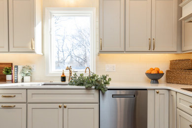 Example of a large transitional u-shaped dark wood floor and brown floor open concept kitchen design in Other with an undermount sink, recessed-panel cabinets, beige cabinets, quartz countertops, white backsplash, subway tile backsplash, stainless steel appliances, a peninsula and white countertops