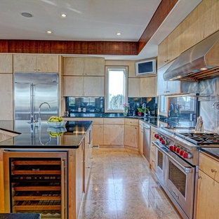 Large contemporary kitchen pantry pictures - Example of a large trendy l-shaped travertine floor kitchen pantry design in Wilmington with flat-panel cabinets, light wood cabinets, two islands, granite countertops, black backsplash, stone slab backsplash, stainless steel appliances and an undermount sink