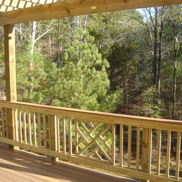 Composite deck with pressure-treated wood Chippendale railing and pergola