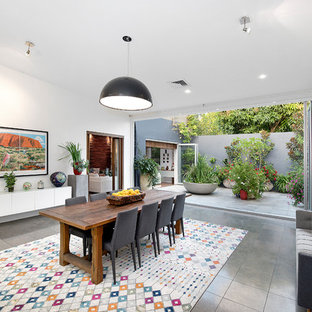 Idées déco pour une salle à manger éclectique avec un mur blanc, un sol gris, un sol en ardoise et aucune cheminée.