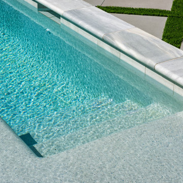 Modern Raised Concrete Pool with White Marble Pavers and Artificial Turf