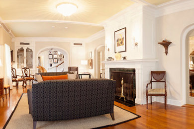 Example of a classic formal and enclosed medium tone wood floor living room design in Austin with beige walls, a standard fireplace, no tv and a stone fireplace