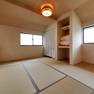 Immagine di una camera da letto etnica con pareti beige, pavimento in tatami e pavimento verde