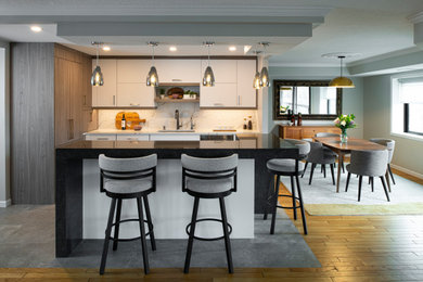 Mid-sized contemporary l-shaped open plan kitchen in Minneapolis with a single-bowl sink, flat-panel cabinets, medium wood cabinets, quartz benchtops, white splashback, engineered quartz splashback, stainless steel appliances, porcelain floors, with island, brown floor, brown benchtop and coffered.