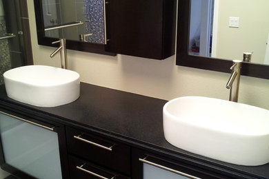 Mid-sized minimalist master black tile ceramic tile alcove shower photo in Los Angeles with a vessel sink, glass-front cabinets, dark wood cabinets, granite countertops and white walls