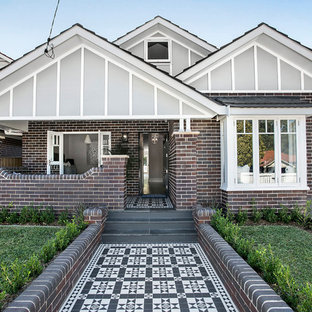 Mid-sized transitional two-storey brick multi-coloured house exterior in Sydney with a gable roof and a tile roof.