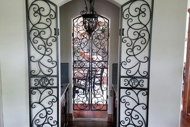 Example of a mid-sized tuscan dark wood floor wine cellar design in Other