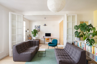 Inspiration pour un grand salon nordique avec un mur blanc, parquet clair et un sol beige.
