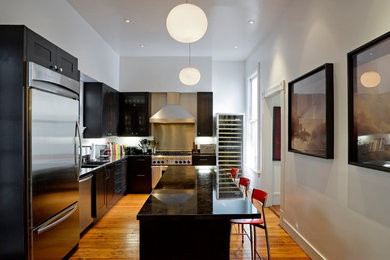 Small contemporary l-shaped separate kitchen in San Francisco with an undermount sink, recessed-panel cabinets, dark wood cabinets, granite benchtops, black splashback, stainless steel appliances, medium hardwood floors and with island.