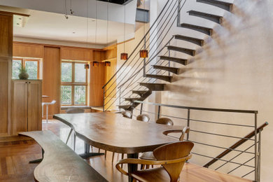 Example of a trendy medium tone wood floor dining room design in New York with white walls and no fireplace