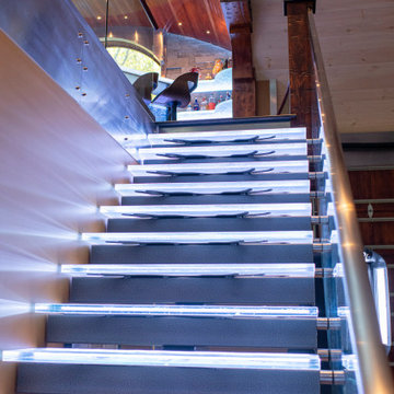Glass private bar and glass stair treads inside a man cave in Michigan