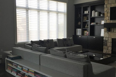 Mid-sized trendy open concept dark wood floor and brown floor family room photo in Detroit with gray walls, a standard fireplace, a stone fireplace and a wall-mounted tv