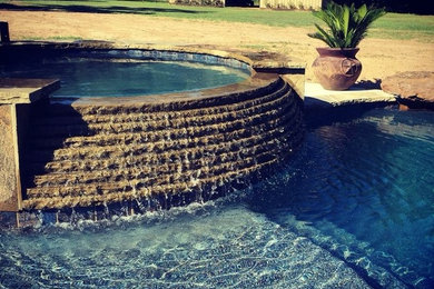 Inspiration for a large timeless backyard stone and custom-shaped lap hot tub remodel in Houston