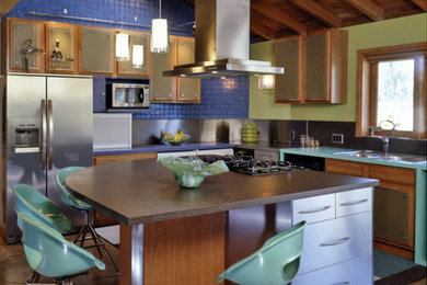 Open concept kitchen - large modern u-shaped concrete floor open concept kitchen idea in Phoenix with a double-bowl sink, light wood cabinets, laminate countertops, gray backsplash, glass tile backsplash, stainless steel appliances and an island