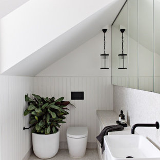 Photo of a contemporary powder room in Sydney with white cabinets, white walls, terrazzo floors, tile benchtops, panelled walls, porcelain tile and grey floor.