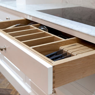 Large eclectic kitchen pantry appliance - Kitchen pantry - large eclectic u-shaped dark wood floor kitchen pantry idea in Dublin with a single-bowl sink, beaded inset cabinets, white cabinets, marble countertops, white backsplash, stone slab backsplash, stainless steel appliances and an island