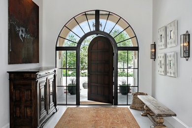 Photo of a mediterranean foyer in Miami with white walls, a single front door and a dark wood front door.