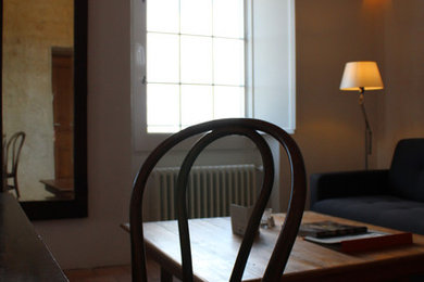 Example of a mid-sized mountain style terra-cotta tile and brown floor family room design in Other with white walls and a wall-mounted tv