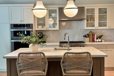 Example of a mid-sized transitional laminate floor and beige floor kitchen design in Orange County with shaker cabinets, light wood cabinets, quartz countertops and an island
